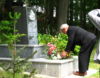 Pan Kolomacky pokládá kytici na pomník.